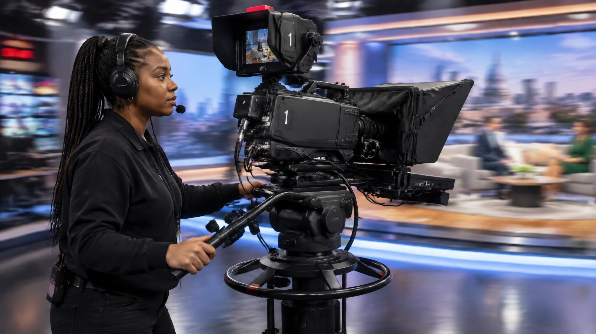 Camera operator panning a studio camera during a live segment
